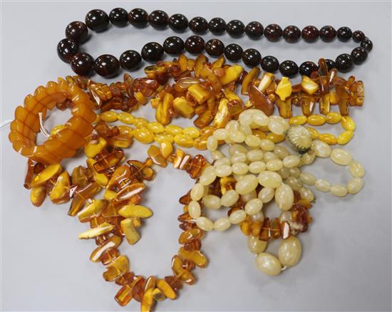Three assorted amber bead necklaces, a pressed? amber bracelet and two other necklaces.